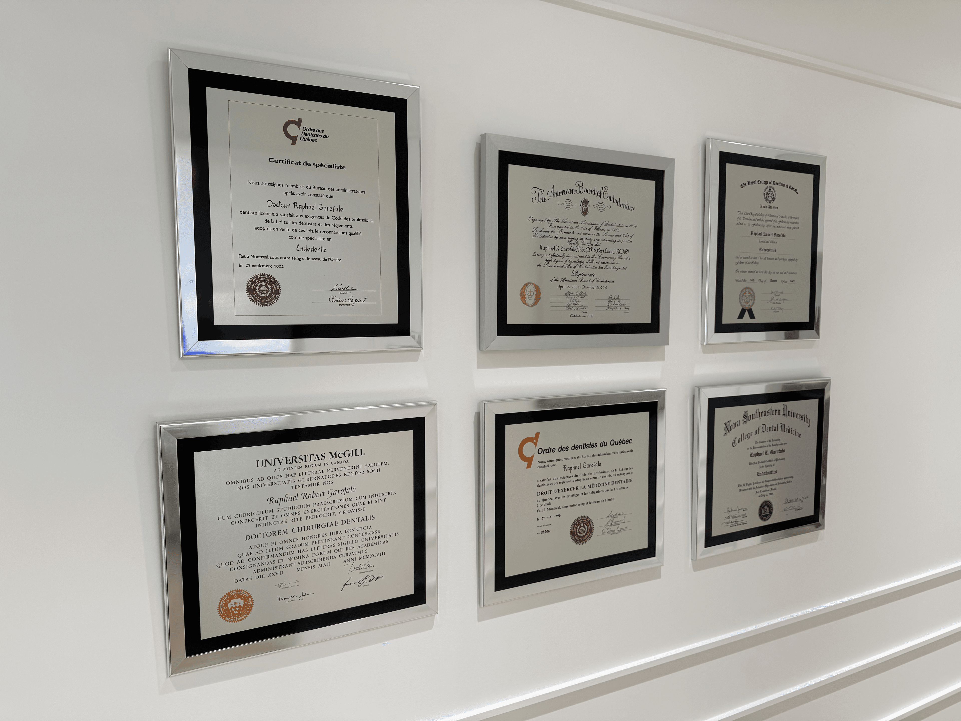 Framed diplomas and board certifications of Dr. Raphael Garofalo displayed at Endodontie Garofalo